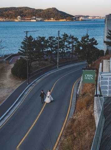 바다 앞 도로를 걷는 신랑 신부